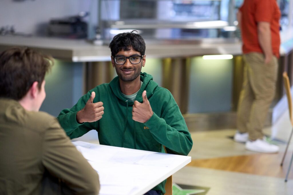 Student celebrating results with thumbs up