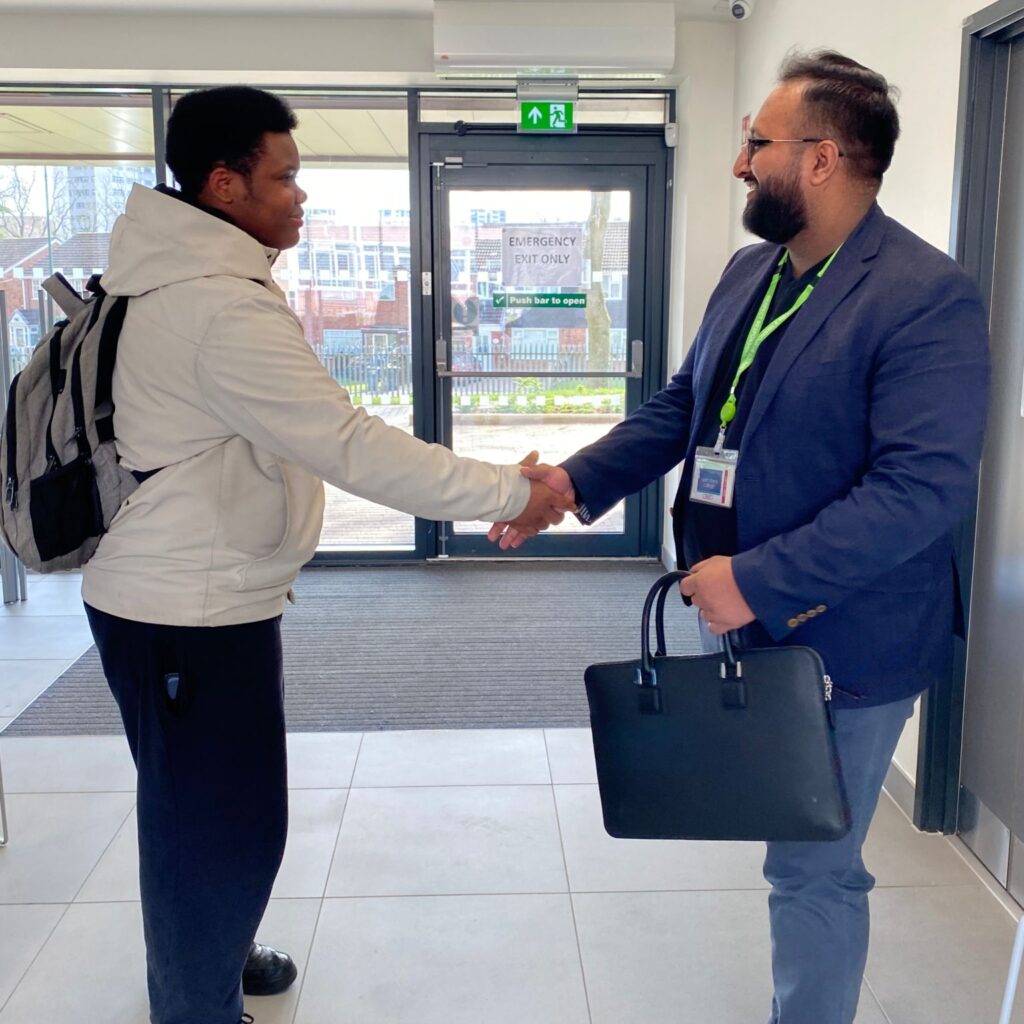 Employer shaking hands with student in entrance