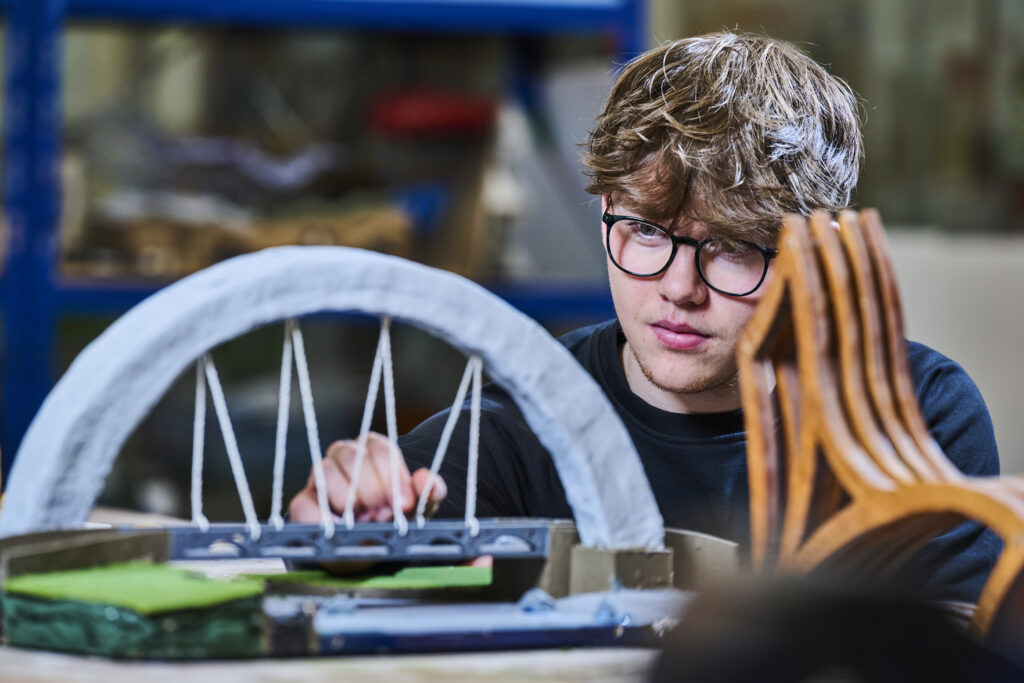 Student looking at his model bridge