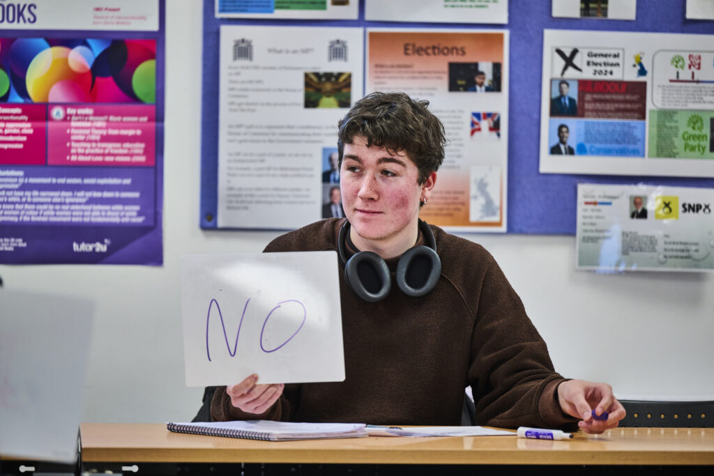 Student holing up 'no' sign in classroom