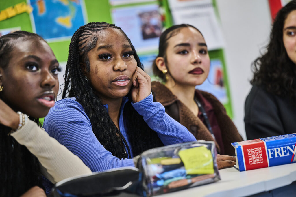Students looking at teacher in French classroom