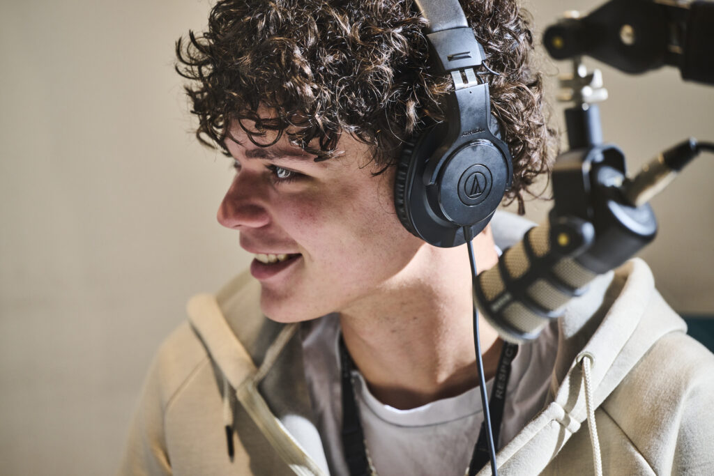 Student with headphones smiling