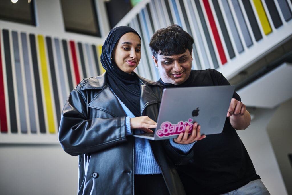 Student support officer showing student something on the laptop