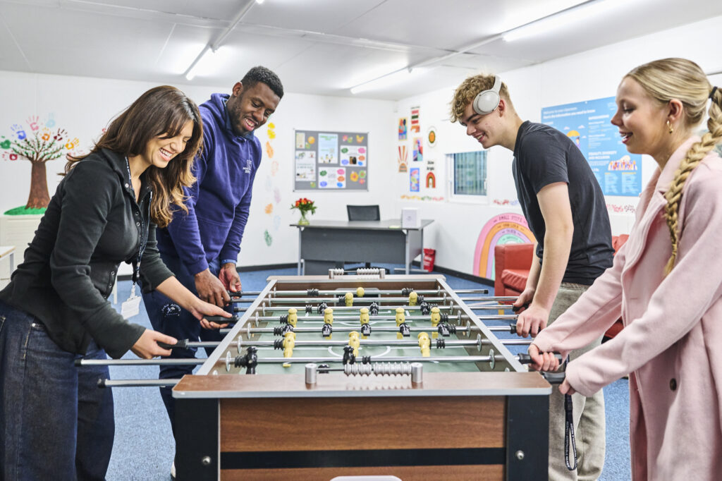Students and student support playing table football