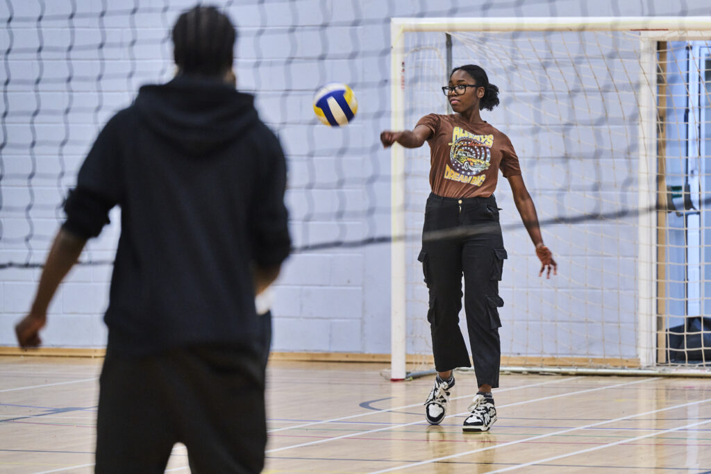 Two students playing volleyball