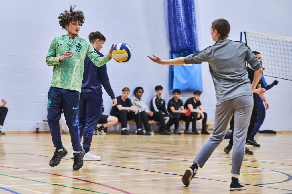 Three students playing volleyball
