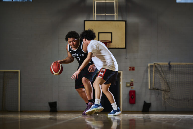 Two students playing basketball