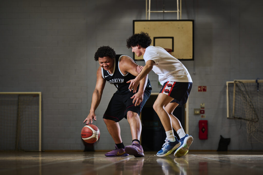 Two students playing basketball