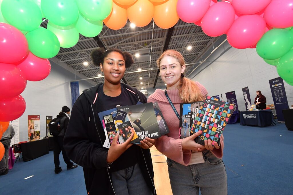 Two students under a balloon arch at the higher education fair